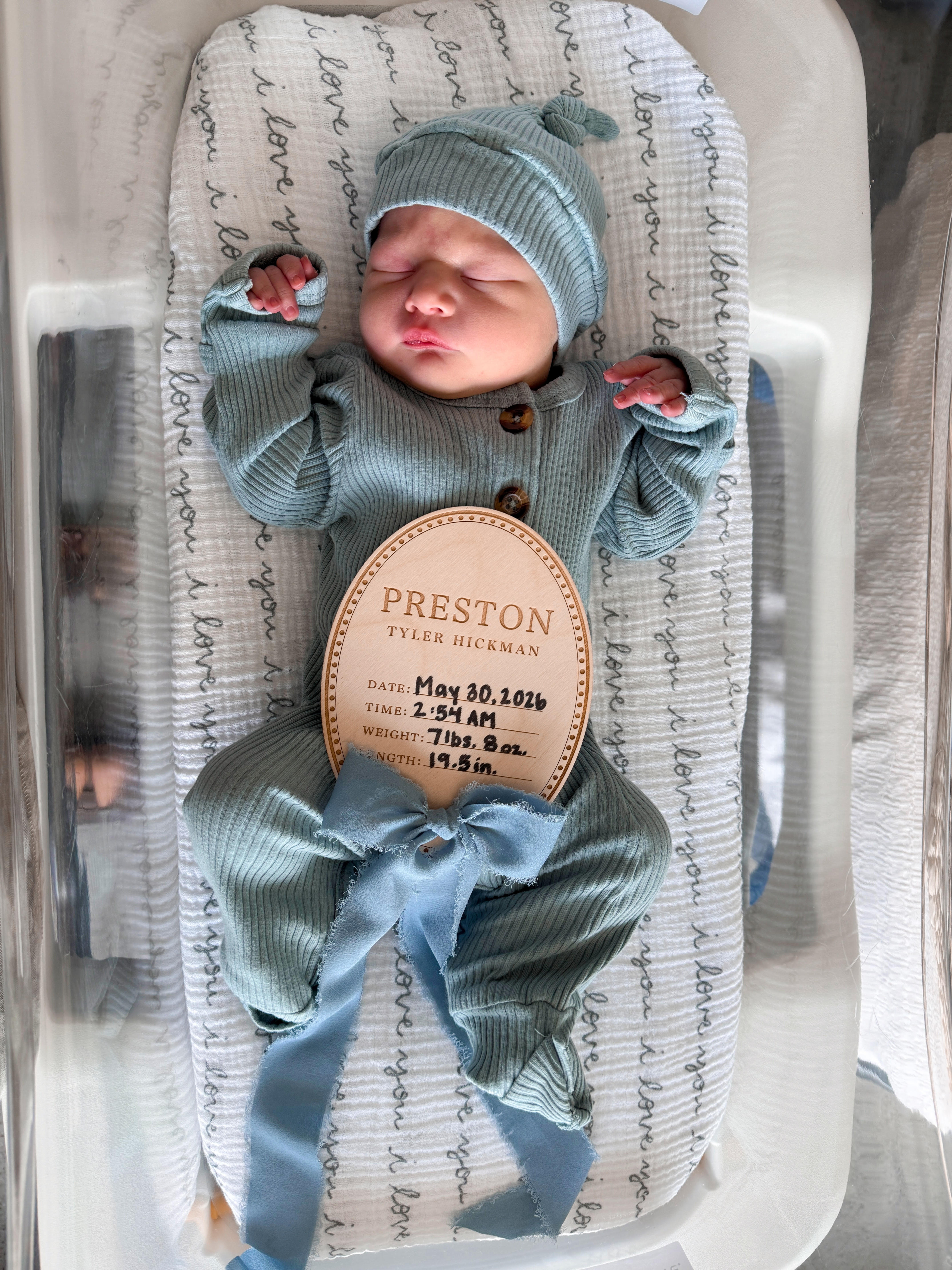 Preston Tyler Hickman, newborn baby, with a birth announcement plaque